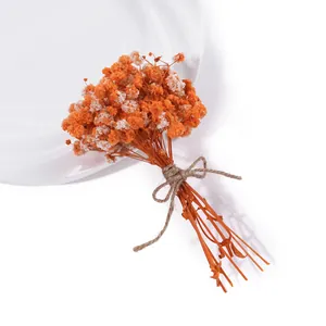 Detailaufnahme eines Mini-Trockenblumenstraußes aus Schleierkraut in Orange und Weiß
