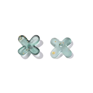 Macro detail showing teal gradient acrylic flower spacers with gold fleck accents