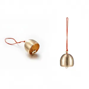 Detailed view of matte brass bell pendant with red cord for DIY crafts and decor.