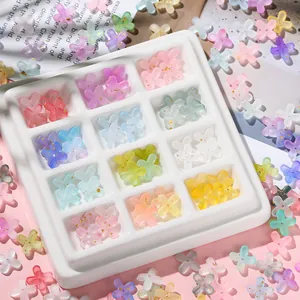 Macro shot of colorful acrylic flower charms with gold leaf accents for DIY jewelry