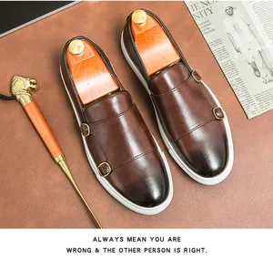 Vista dettagliata dei mocassini monk strap marroni con finitura in pelle lucida