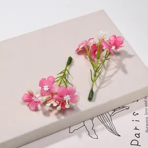 Vista dettagliata di piccoli fiori di seta artificiale rosa per creazioni di capelli