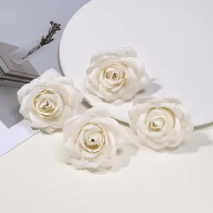 Primo piano di teste di rose artificiali bianche con gocce di rugiada per accessori fai da te