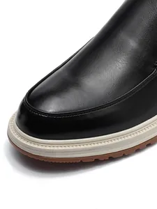 Detailed macro shot of black leather loafer toe showing fine stitching and textures