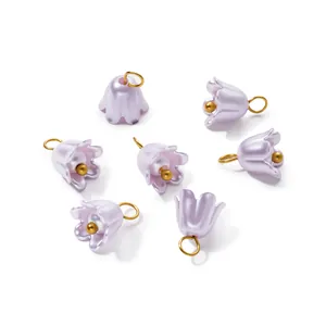 Detailed view of pearlescent light purple flower pendants with golden rings for DIY jewelry