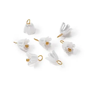 Detailed view of iridescent pearl flower pendants with gold rings for DIY jewelry.