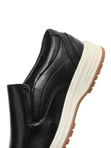 Detail view of black leather loafer heel with textured fabric and thick sole