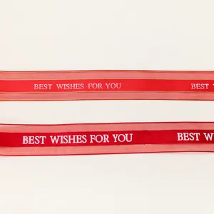 Dettaglio macro del nastro rosso con bordi dorati e scritta Best Wishes For You