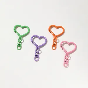Gros plan de quatre fermoirs mousquetons en forme de cœur colorés pour bijoux artisanaux
