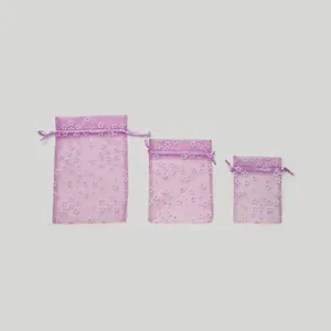 Gedetailleerd overzicht van drie paarse organza zakjes met bloemen in verschillende maten