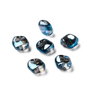 Primo piano di perle di vetro sfaccettate blu e grigie cangianti per fare gioielli