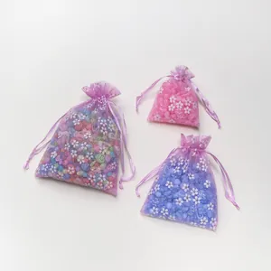 Detailweergave van paarse organza zakjes met bloemen gevuld met gekleurde kralen
