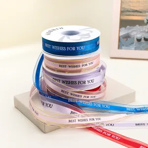 Pila di nastri di raso colorati con bordi dorati e testo Best Wishes per confezioni regalo