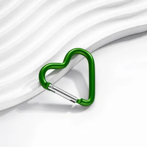 Gros plan détaillé d'un mousqueton en alliage d'aluminium vert en forme de cœur avec ressort