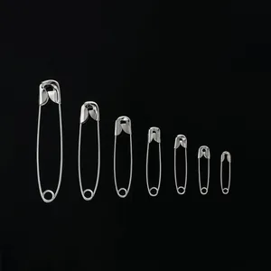 Set di sette spille da balia in argento di varie dimensioni su uno sfondo nero profondo