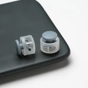 Close-up of translucent plastic cord locks with grey toggle buttons and springs