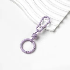 Dettaglio portachiavi in lega di zinco viola macaron con molla e anello circolare.
