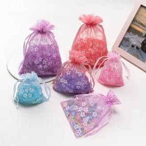 Gedetailleerd overzicht van kleurrijke organza trekzakjes met bloemenpatroon voor cadeau