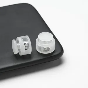 Detailed view of translucent white double-hole plastic spring cord locks with internal springs