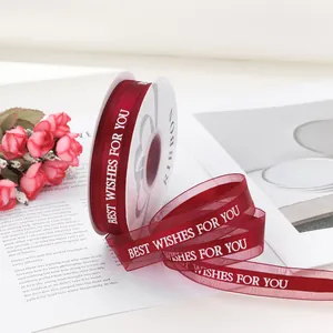 Vista dettagliata del nastro in organza rossa con scritta bianca Best Wishes For You