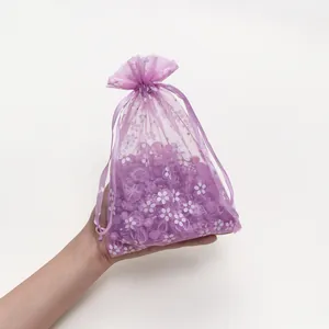 Gedetailleerd overzicht van paarse organza tas met bloemen en paarse kralen