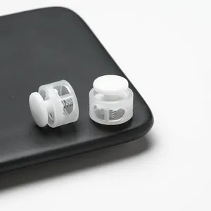 Macro close-up view of white plastic double-hole spring cord locks for drawstring adjustment