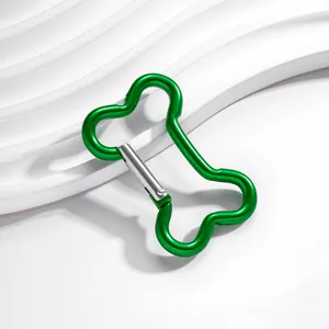Gros plan d'un mousqueton en aluminium vert en forme d'os sur un support blanc
