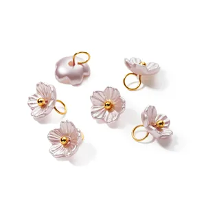 Detailed view of six pearlescent ABS flower charms with gold loops for DIY jewelry