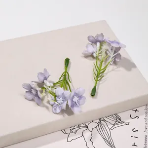 Dettaglio di piccoli fiori di seta viola per accessori per capelli fai da te
