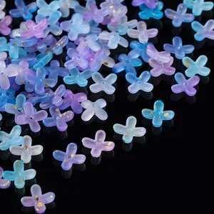 Macro detail of gradient purple and blue acrylic flower beads with gold leaf speckles.