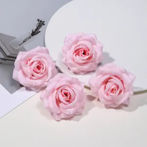 Dettaglio di quattro teste di rose rosa artificiali con realistiche gocce di rugiada