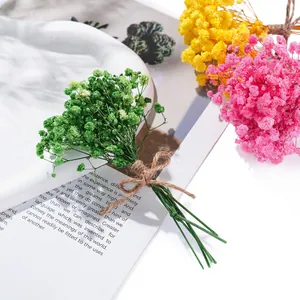 Detailaufnahme bunter Mini-Trockenblumensträuße aus Schleierkraut mit Juteschnur