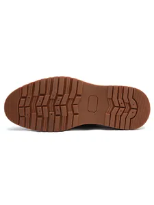 Macro detailed view of the non-slip brown rubber sole for business casual leather loafers