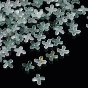 Macro view of frosted acrylic four-petal flower beads with elegant gold foil flecks