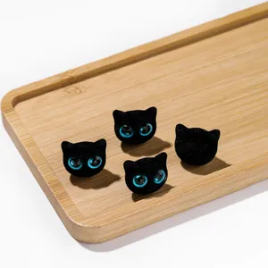Vue détaillée de perles de chat floquées noires avec yeux bleus pour bijoux DIY