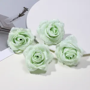 Dettaglio di quattro boccioli di rosa in seta verde chiaro con gocce di rugiada DIY.