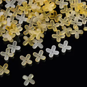 Macro view of gradient acrylic four-petal flower beads with gold flecks for DIY jewelry