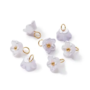 Macro detail of pearlescent ABS lily flower charms with gold jump rings for DIY crafts