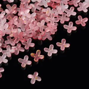 Macro detail of pink frosted acrylic flower beads with gold foil splatter for DIY