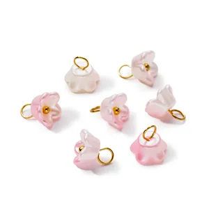 Detailed macro view of pearlescent ABS flower charms with golden hanging loops