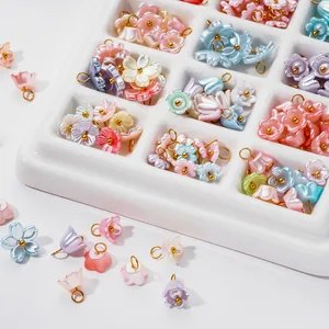 Close-up of iridescent ABS pearl flower charms with gold loops for DIY jewelry