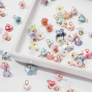 Detailed close-up of pearlescent ABS flower pendants with gold rings for DIY jewelry