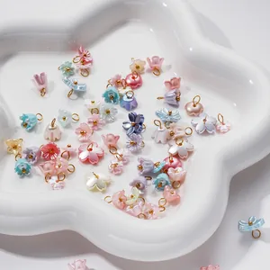 Detailed view of assorted pearlescent 3D flower charms with gold loops for DIY jewelry