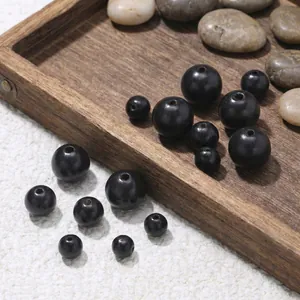 Detailed macro shot of 6-10mm natural black sandalwood loose beads for DIY jewelry