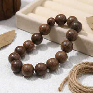 Makro-Detail eines Armbands aus natürlichen goldenen Sandelholzperlen auf einem Display