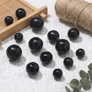 Close-up of black sandalwood loose beads in various sizes with natural props
