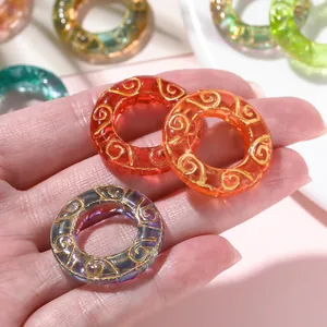 Close-up of translucent resin donut rings with gold swirl patterns for DIY jewelry