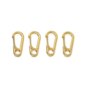 Vista dettagliata di quattro mini moschettoni metallici dorati per artigianato DIY