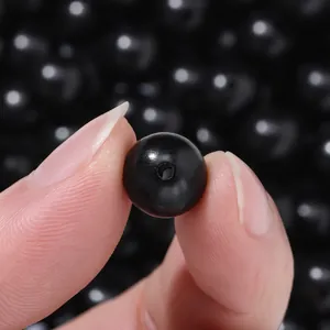 Macro detail shot showing a single polished black sandalwood bead for DIY jewelry.