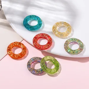 Detailed view of colorful translucent glass rings with gold swirl patterns for DIY jewelry